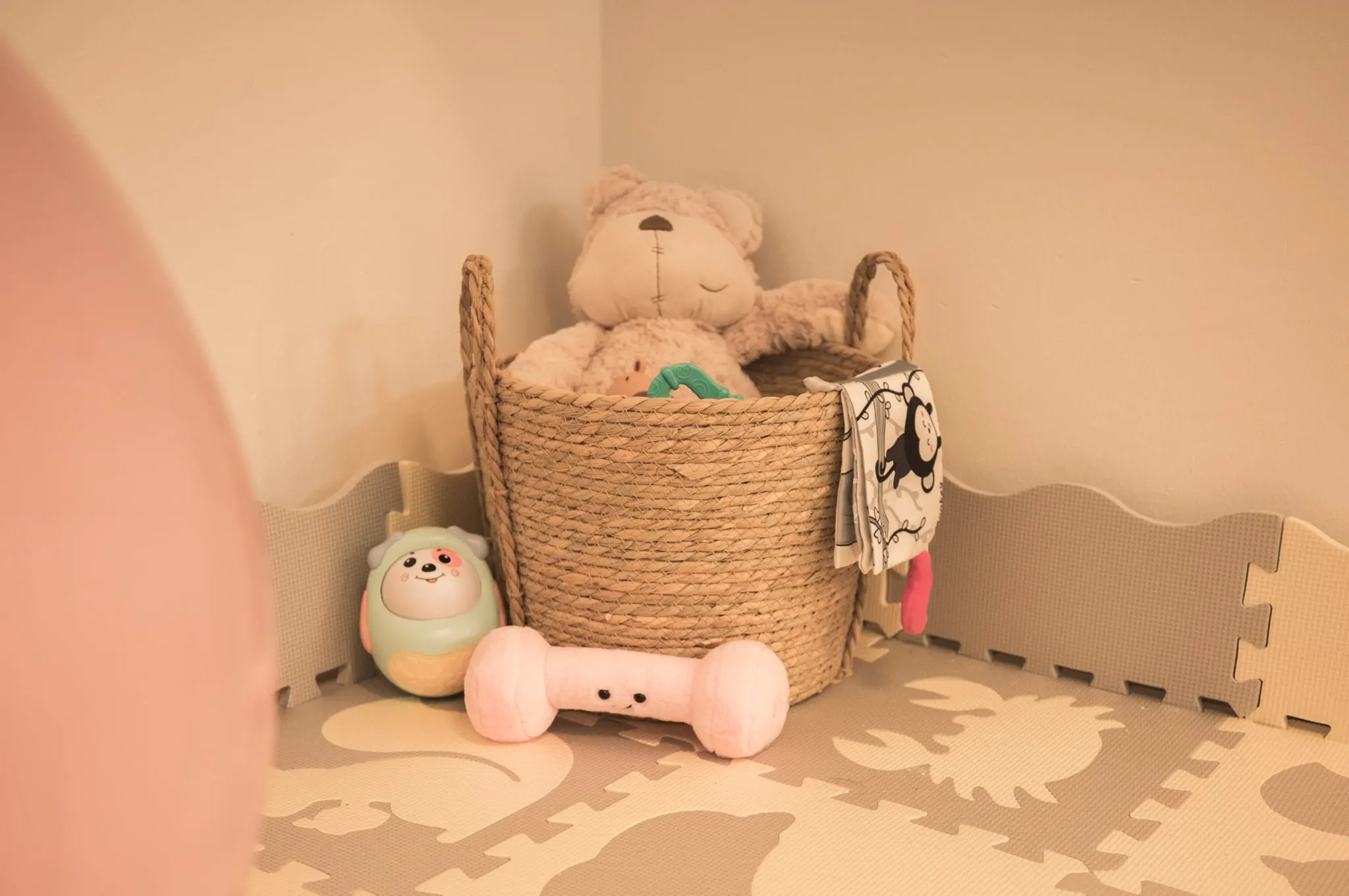 Játszósarok a kicsiknek: fonott kosár plüssállatokkal és puha szivacsszőnyeg