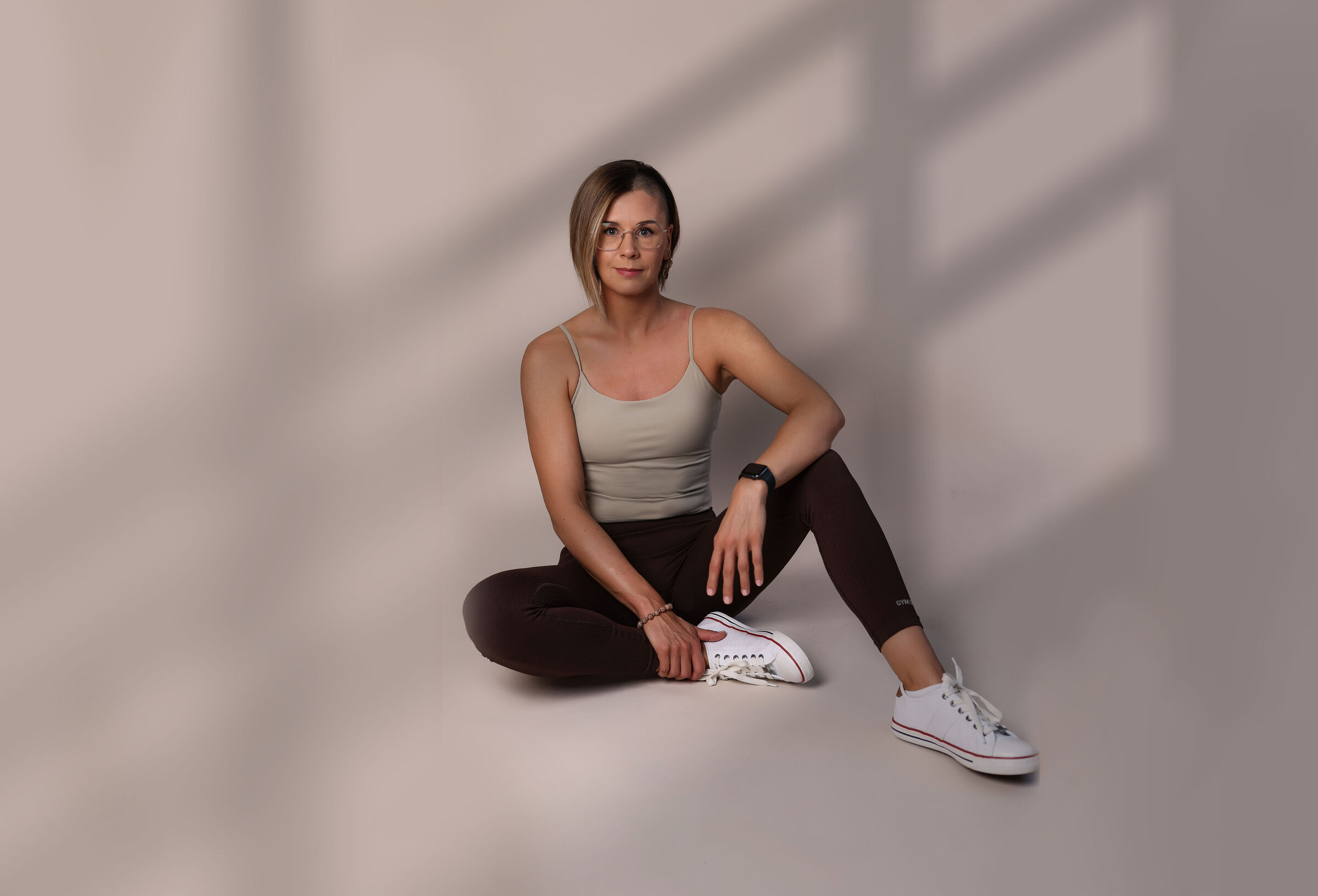 Pánczél Gabi várandós- és kismama-edző törökülésben ülve mosolyog